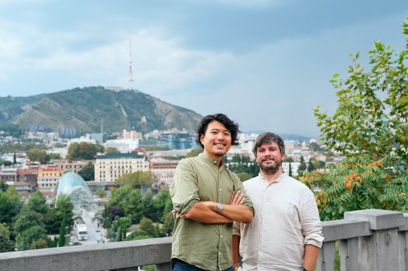 トビリシの街を背に並ぶ浅野俊貴とTornike Tvalavadze